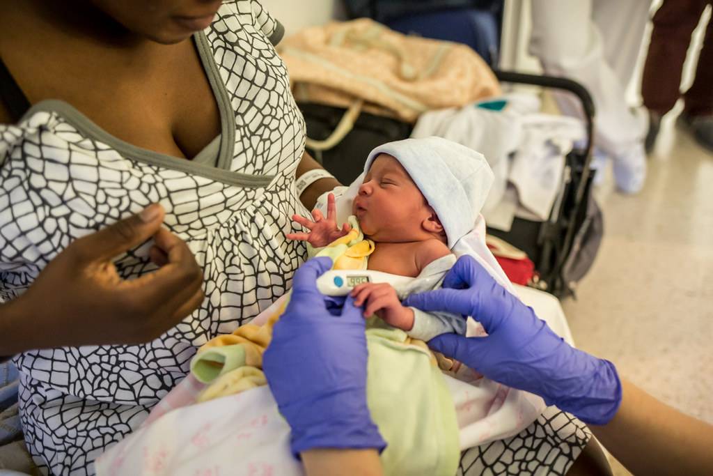 Una enfermera toma la temperatura de un recién nacido. FOTO: Ariadna Creus y Ángel García (Banc Imatges Infermeres)